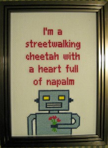Crossstich image with a robot holding flowers and the text "I'm a streetwalking cheetah with a heart full of napalm." No Really.